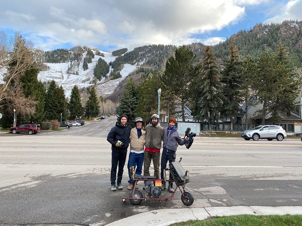 Four men pose at the foot of the Aspen ski area.