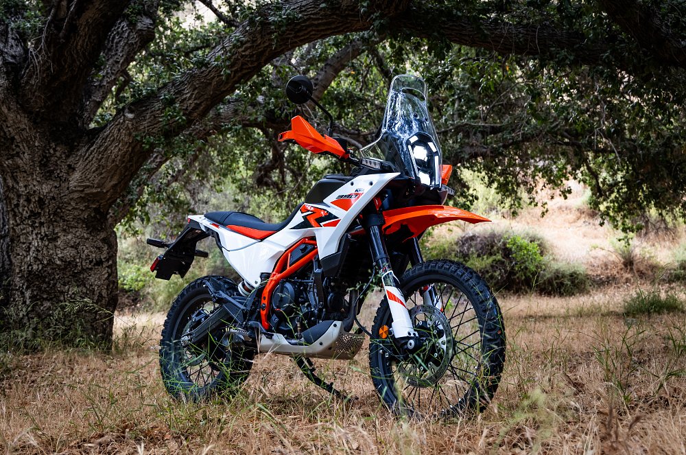 2025 KTM 390 Adventure parked under a tree.